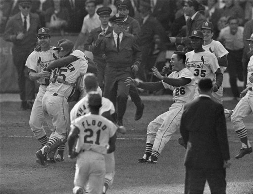 Members of the St. Louis Cardinals stand for a moment of silence for the  late New York Yankee Yogi Berra before a game against the Cincinnati Reds  at Busch Stadium in St.