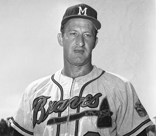 Milwaukee Brewers broadcaster Bob Uecker (L) looks into a tuba as